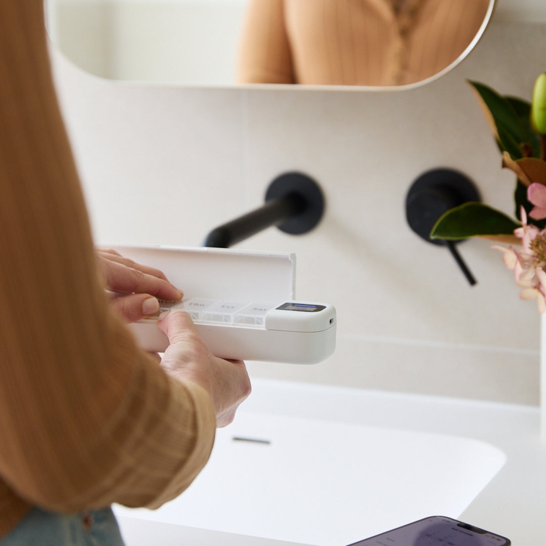 Using daily smartphone and smartwatch connected pill organiser in bathroom